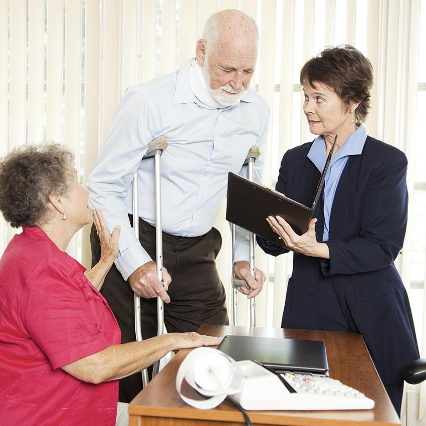 lawyer talking to elderly couple with man in crutches